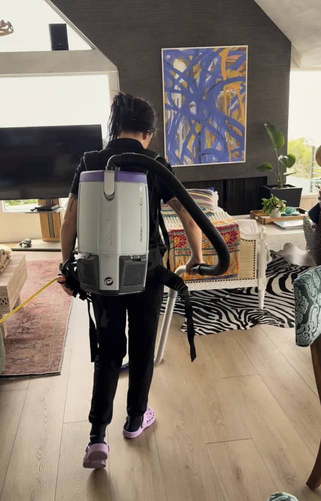 Gabby vacuuming an apartment with professional equipment