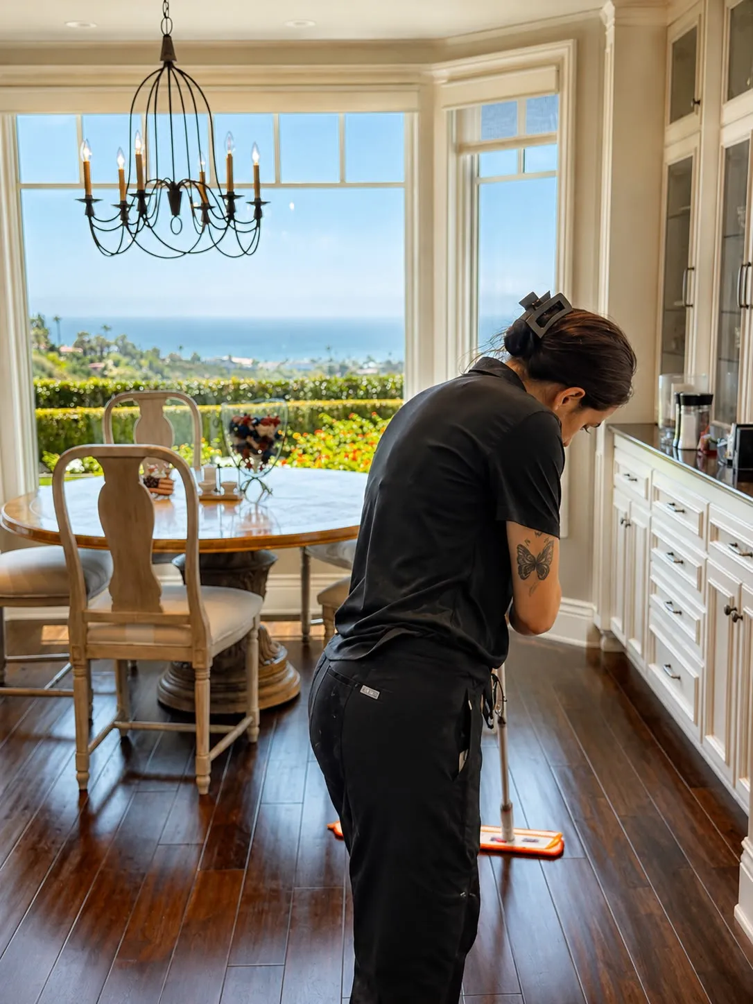 Gabby mopping hardwood floors in an ocean-view Orange County dining room