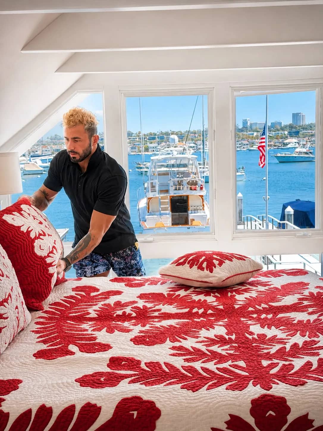 Paul making the bed in a Newport Beach waterfront bedroom overlooking the harbor