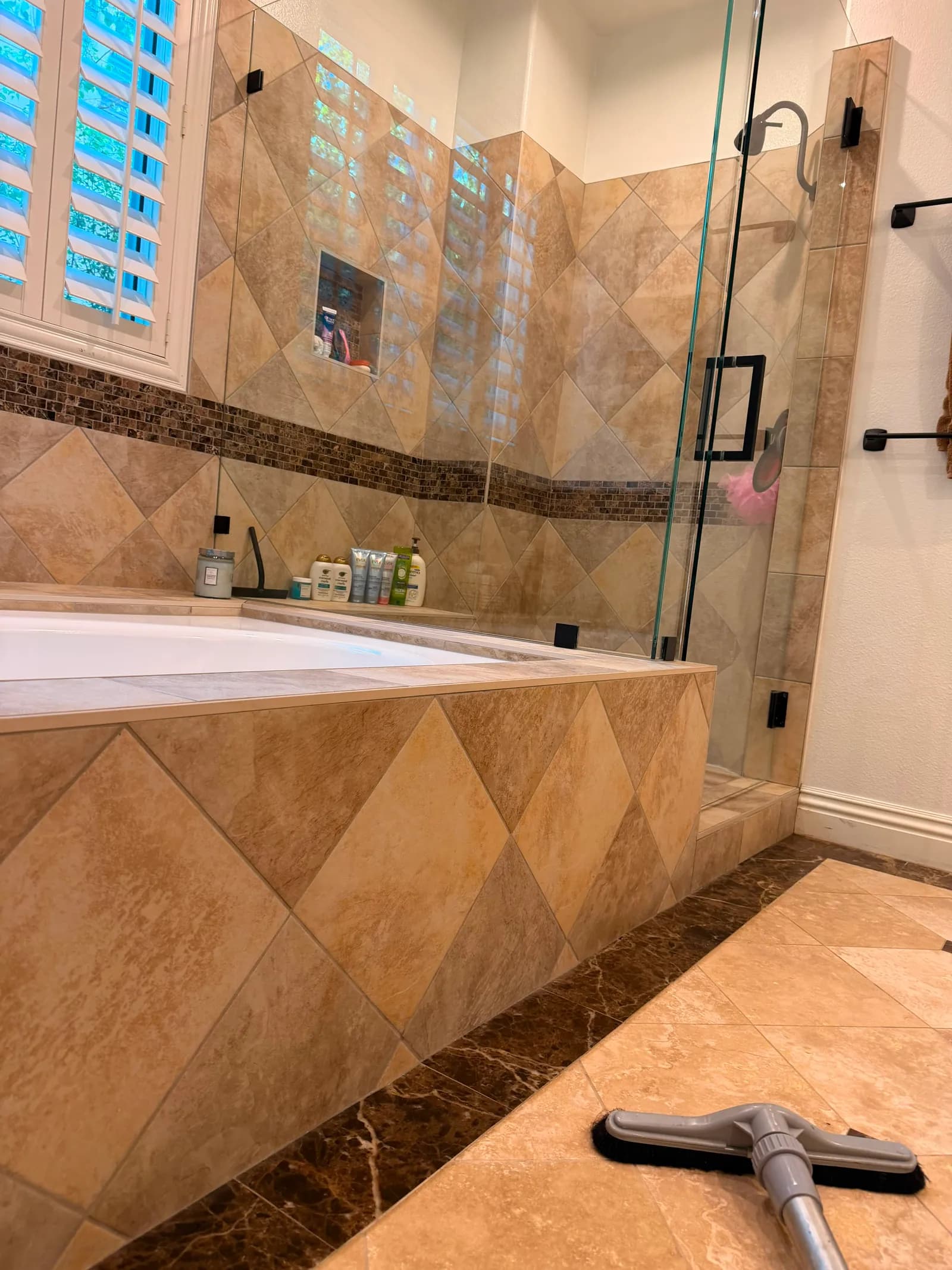 Deep-cleaned soaking tub and glass shower in a travertine-tiled Orange County bathroom