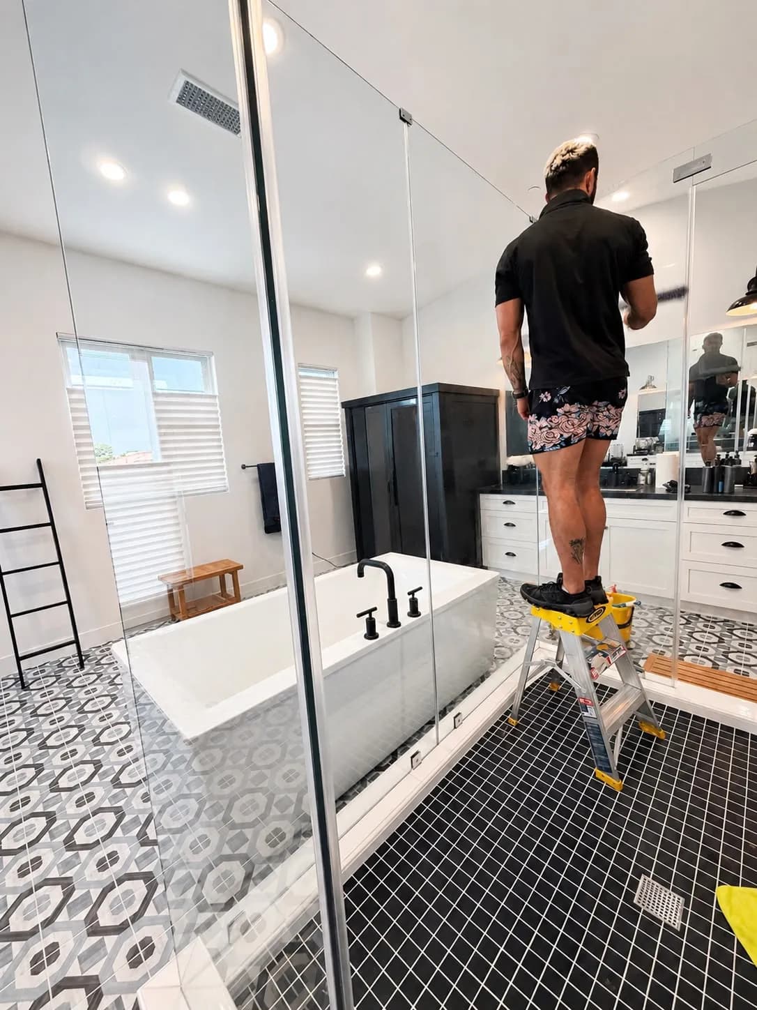 Paul detailing a floor-to-ceiling glass shower enclosure in a designer Irvine bathroom